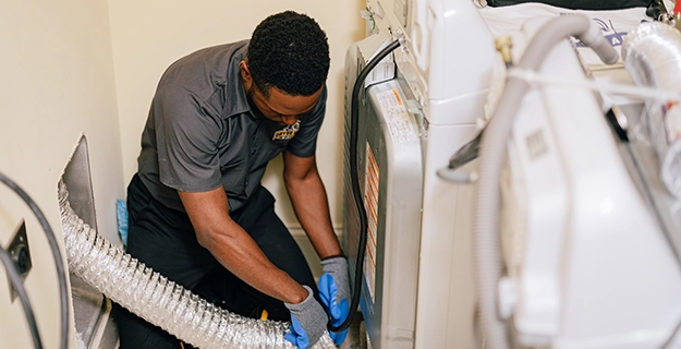 Dryer Vent Wizard technician connecting vent to dryer.
