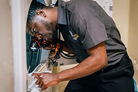 Male dryer vent cleaning professional peering into dryer cleaning dryer lint screen.